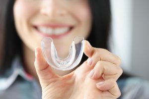 patient holding a clear mouthguard